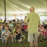 A man standing in front of a crowd under a tent.